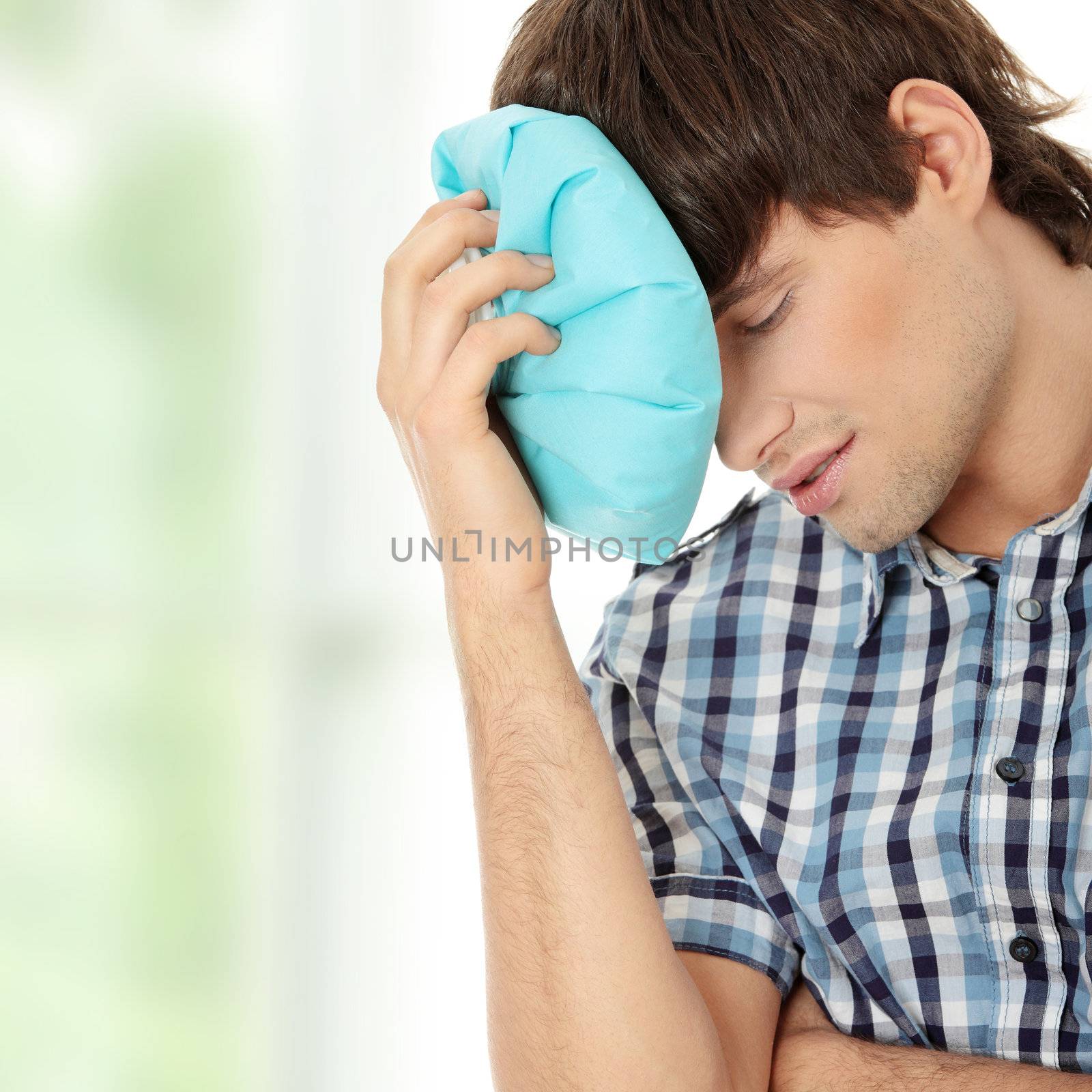 Man with ice bag for headaches, migraines ,hangover and injury