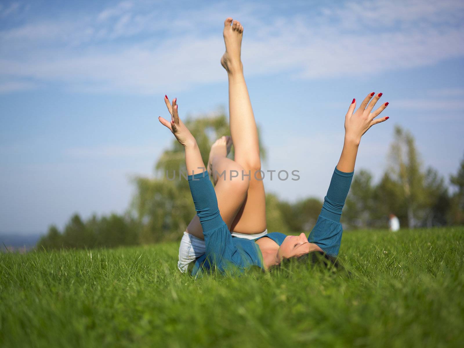 Young woman relaxing in park on green grass