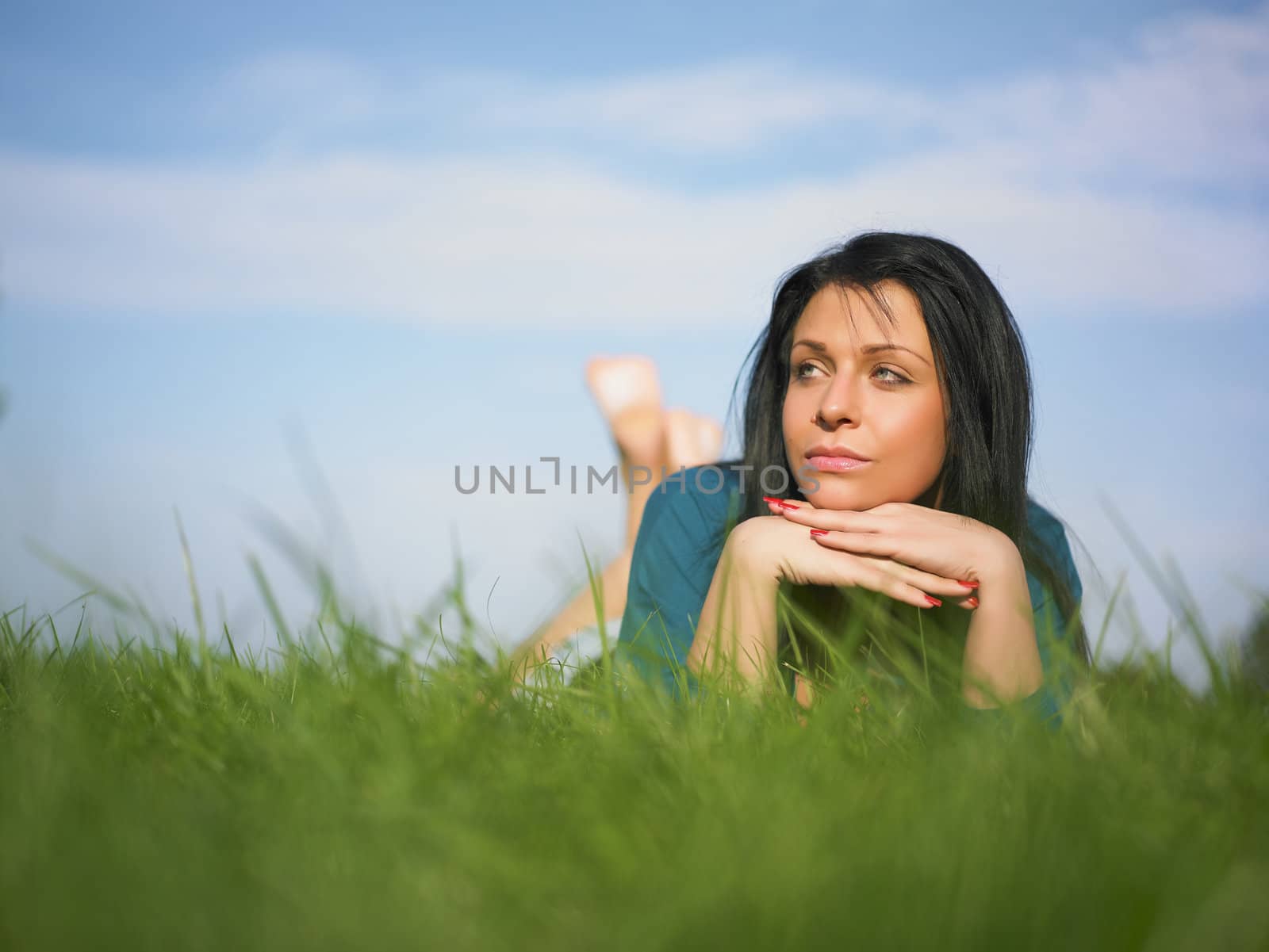 Young woman relaxing in park on green grass