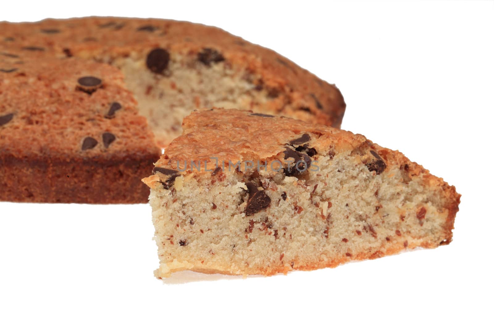 Image of a slice of cake in front of the rest of it, shot against a white background with shadows.Selective focus on the slice.