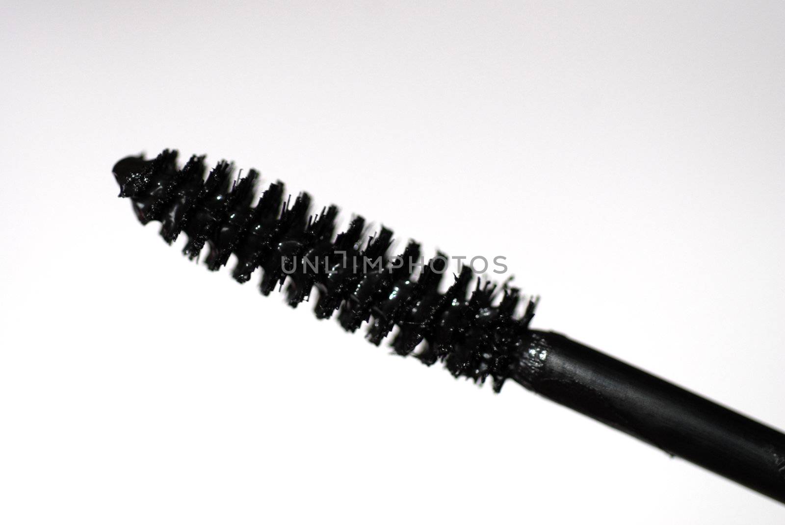 Extreme close-up of a mascara wand against a white background