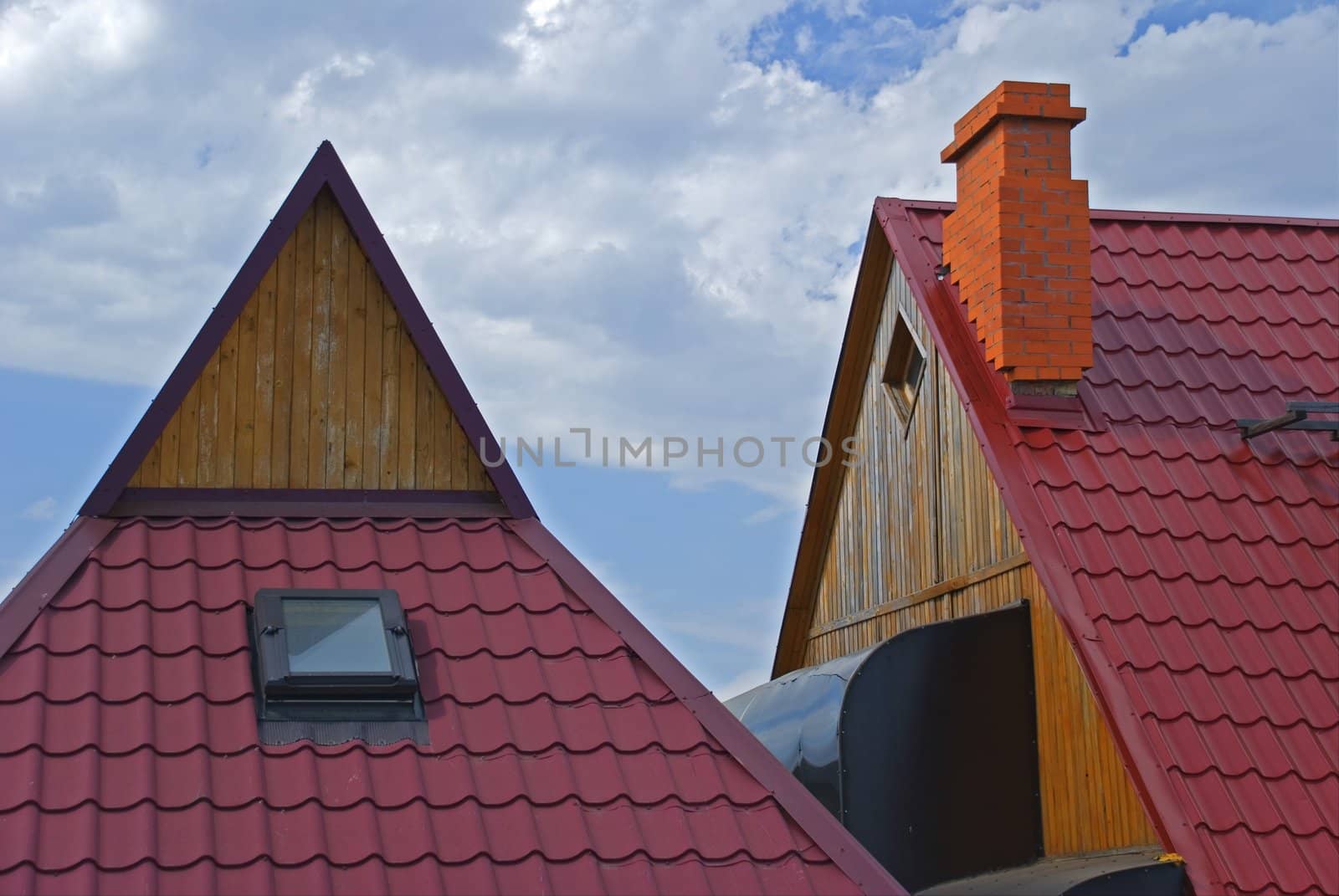 Roofs of houses covered red tile on a background of the sky