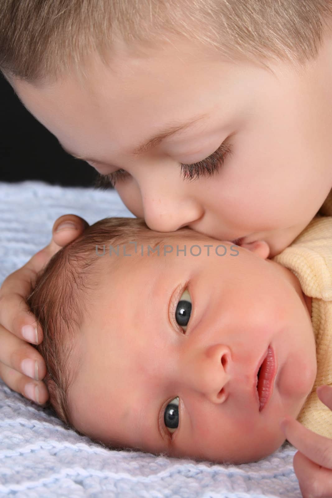 Blond boy with his newborn baby brother