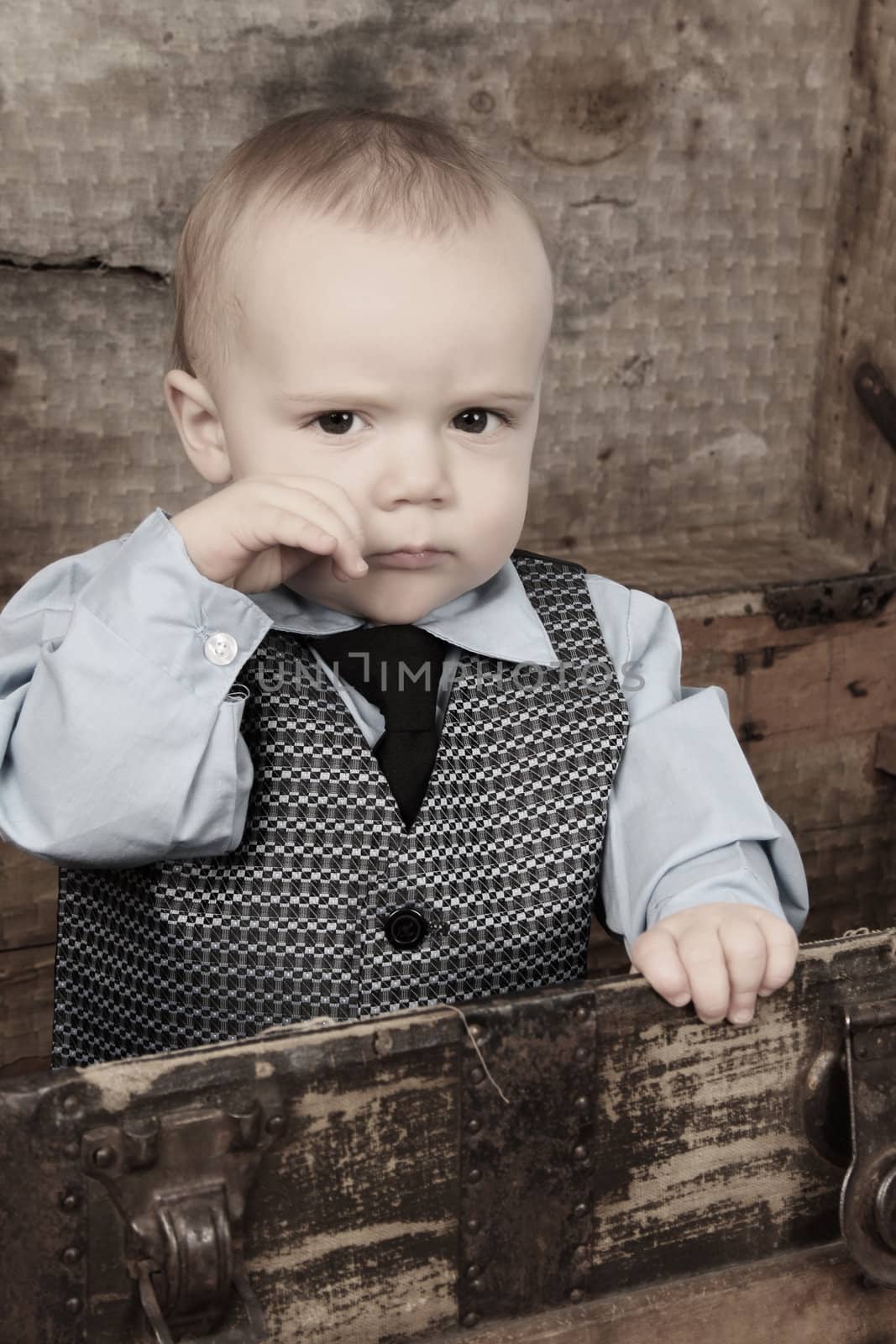 Baby boy playing inside an antique trunk