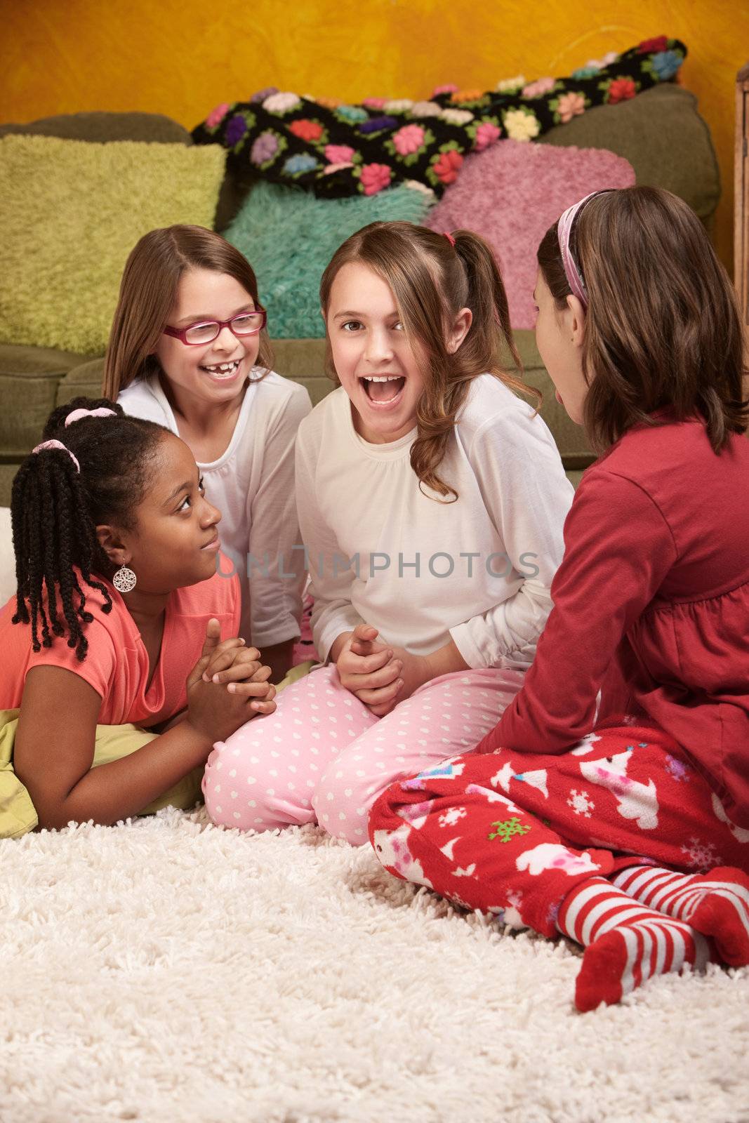 Four happy little girls sharing stories at a sleepover