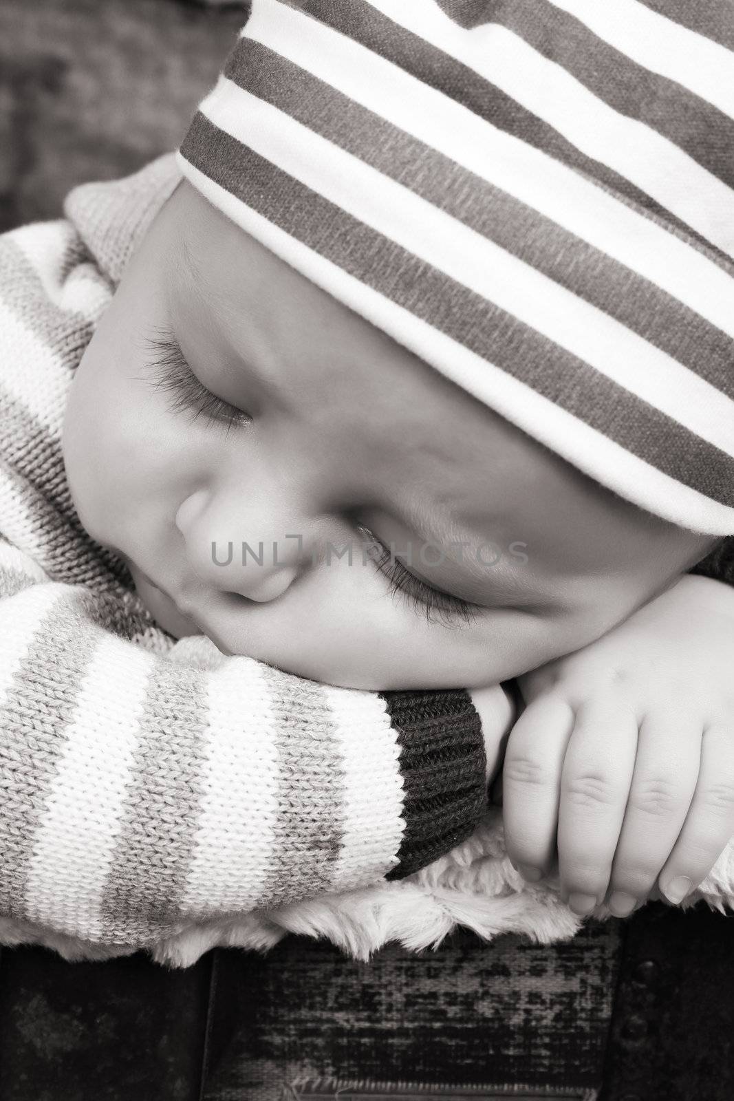 Beautiful baby boy sleeping in an antique trunk