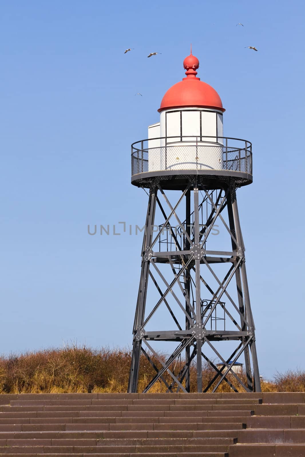 Lookout tower at the coast with blue sky background and seagulls