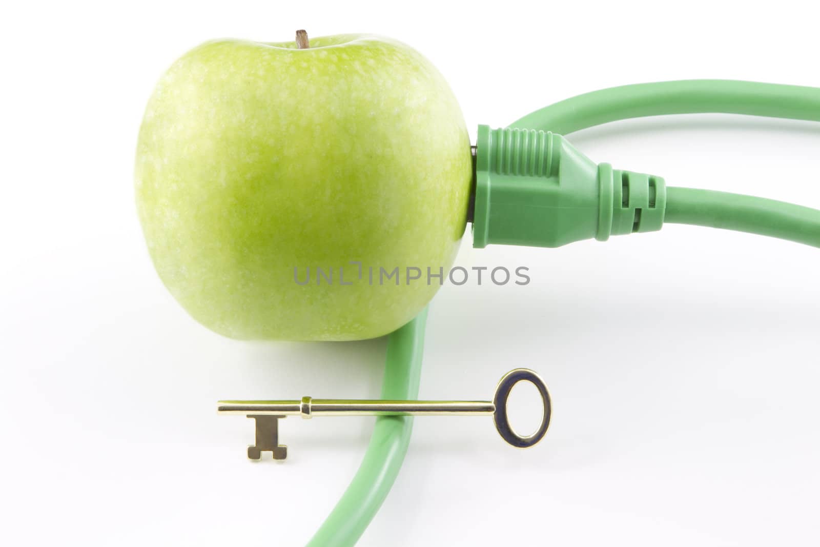 Golden key sits on electric cable with its plug inserted into green apple to represent the challenging key to a clean energy future