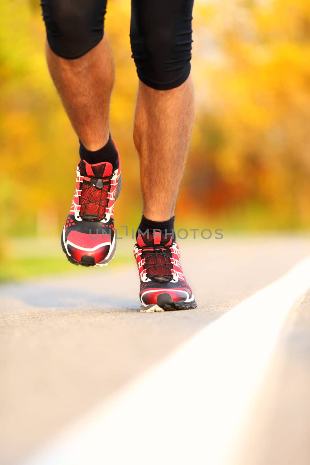 Running shoes on runner outdoors. Closeup of man jogging and training for marathon.