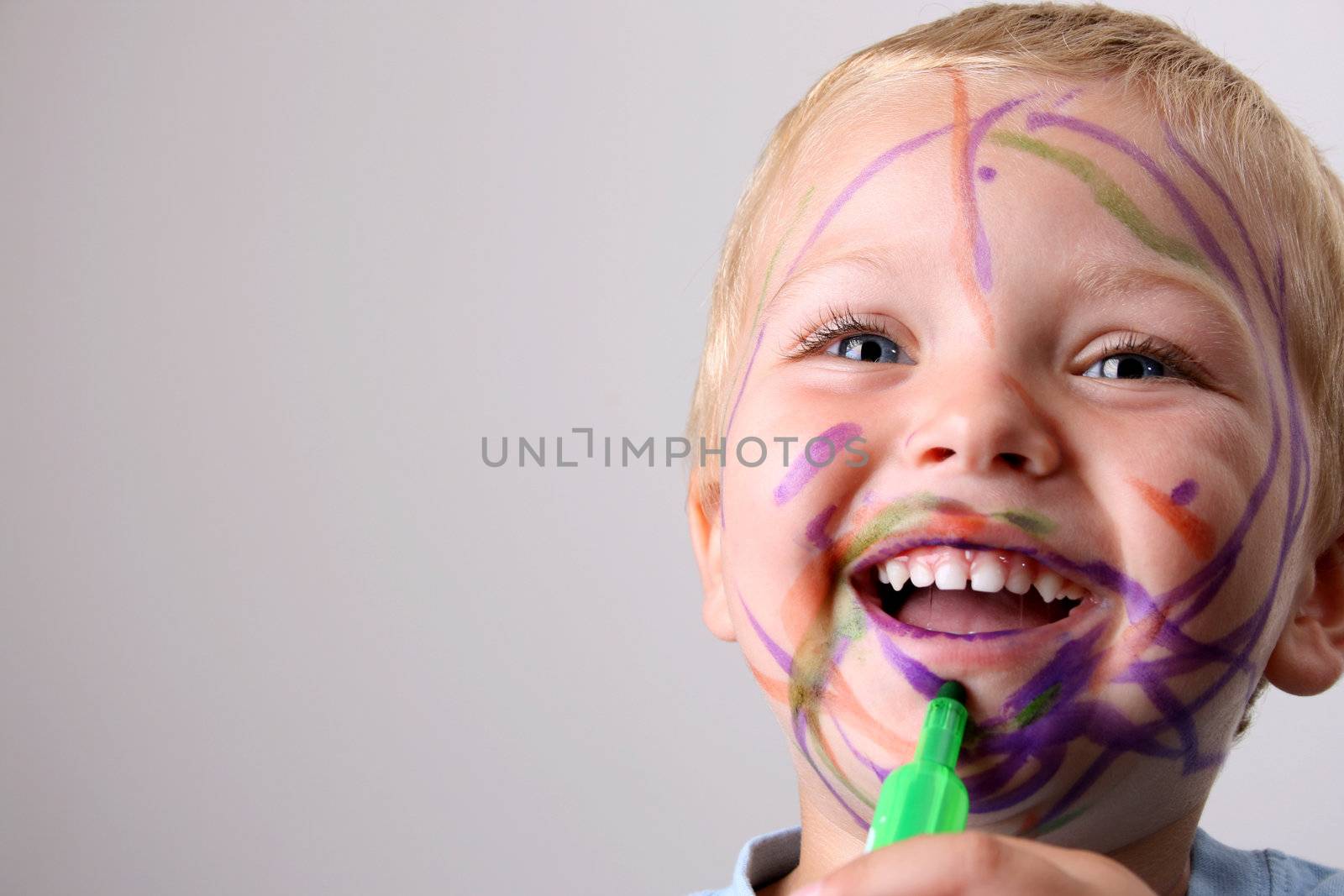 Laughing Toddler playing with colored pens making a mess
