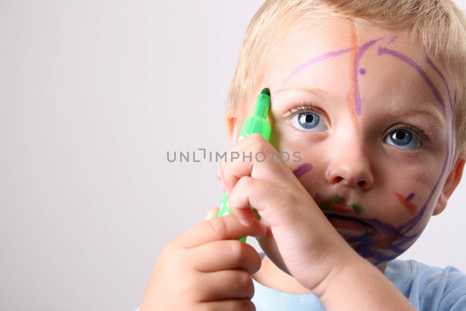 Laughing Toddler playing with colored pens making a mess