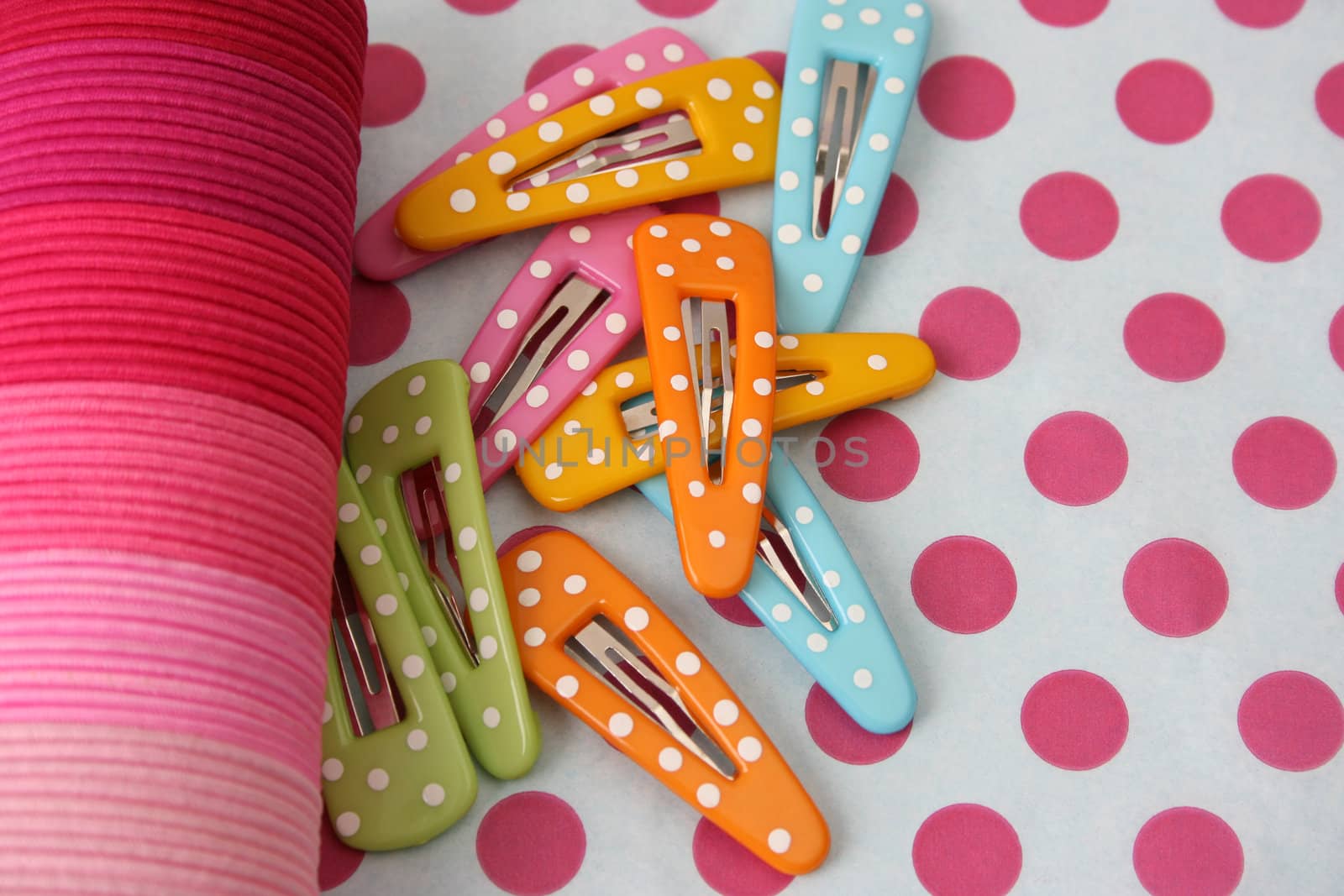Brightly colored polka dot hair accessories on a polka dot background