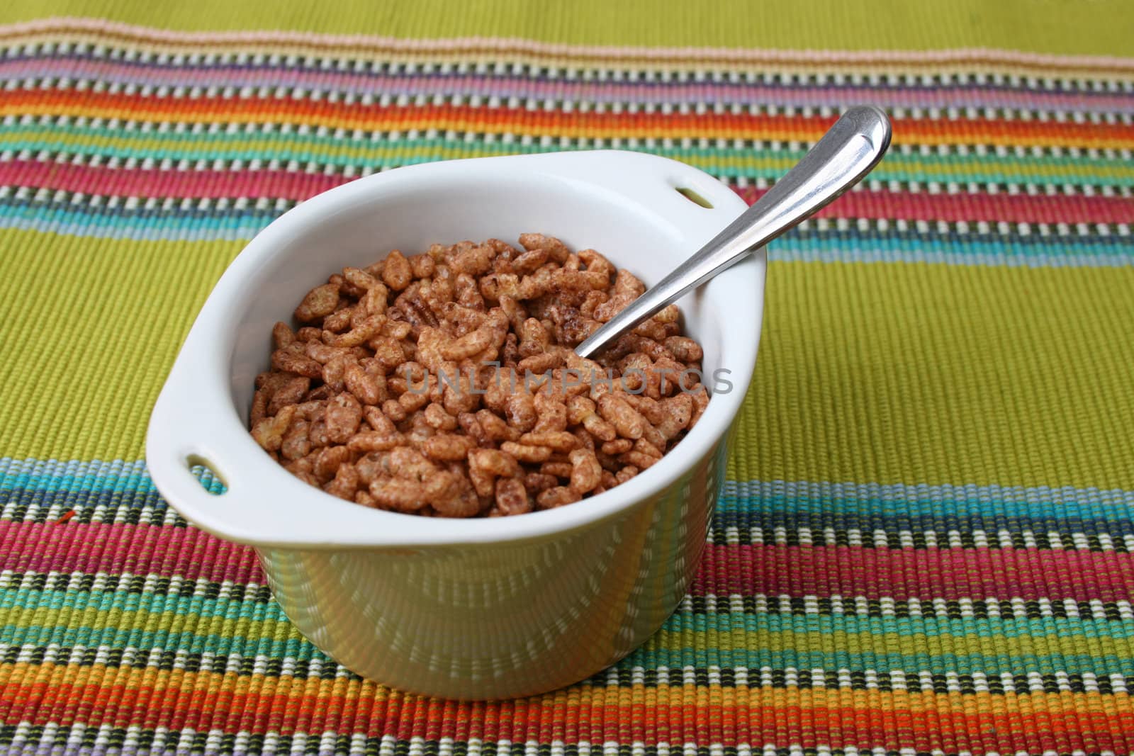 Cereal in a green bowl on a colorful placemat