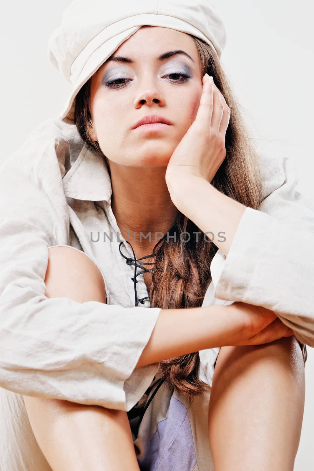 Young woman in white suit, sit in studio