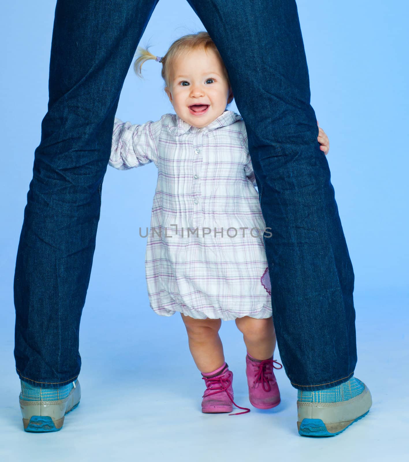 cute baby girl in pink and white stylish outfit with parents in studio