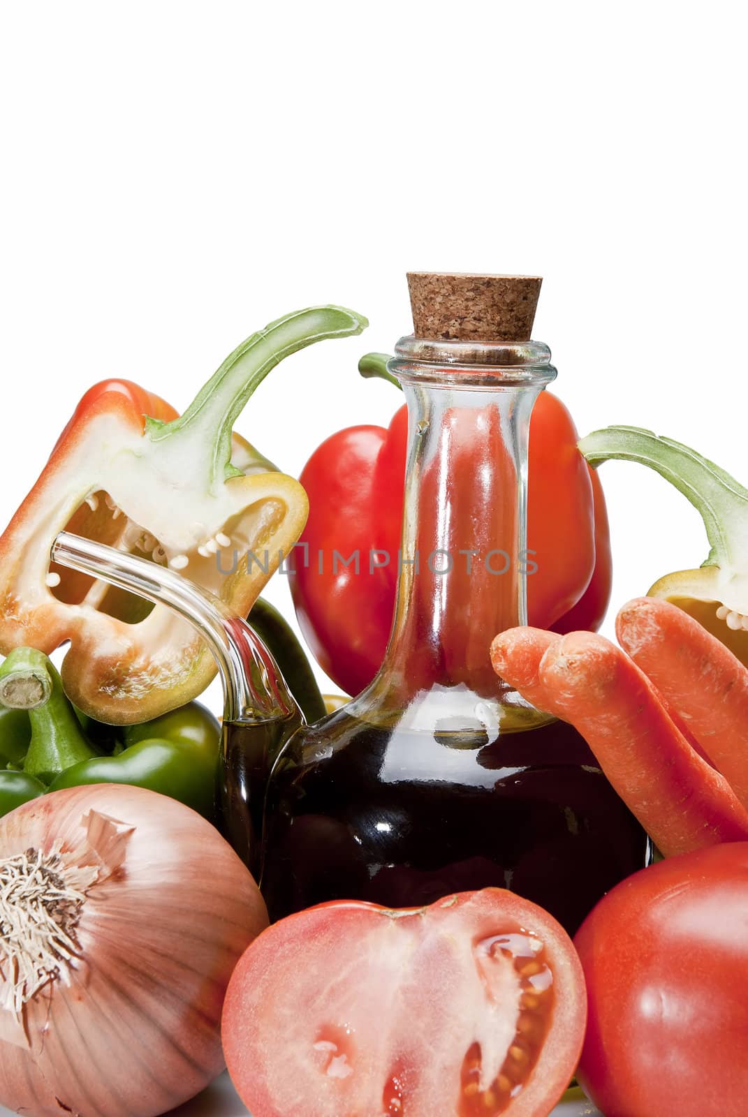 Olive oil and some vegetables like tomatoes, peppers and onions to make gazpacho isolated over a white background.