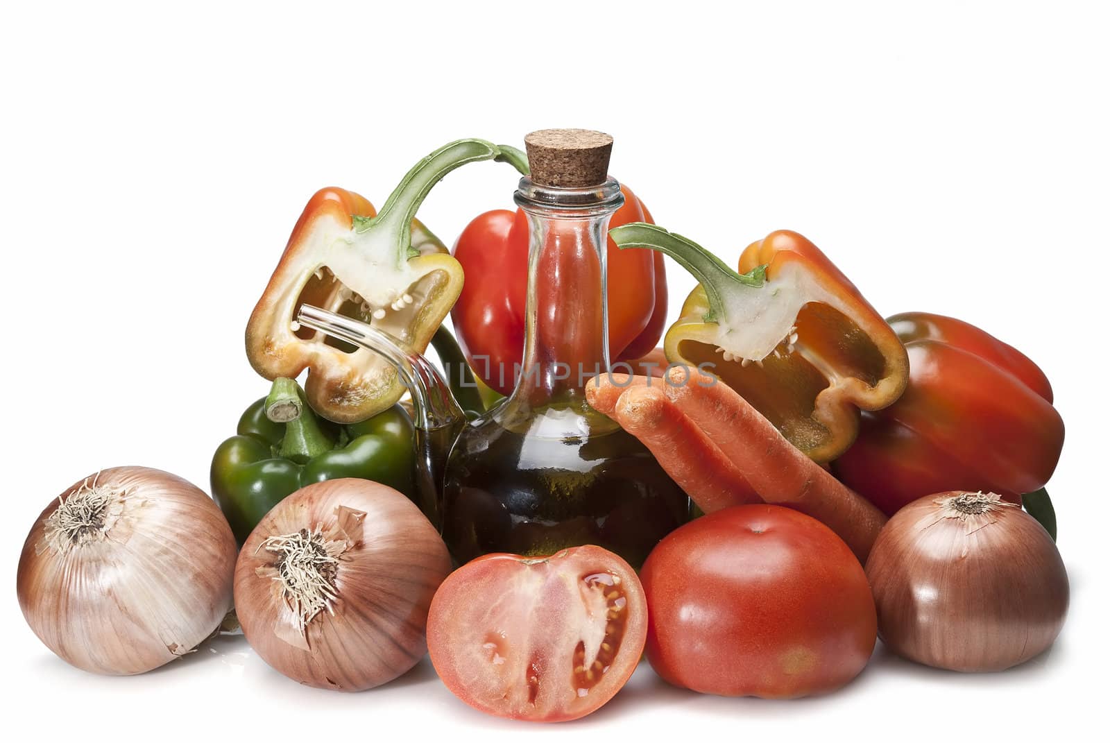 Olive oil and some vegetables like tomatoes, peppers and onions to make gazpacho isolated over a white background.