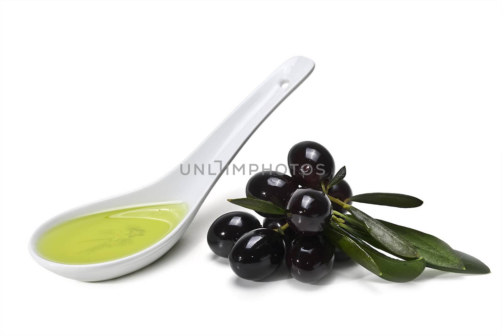 Black olives and a spoonful of olive oil isolated over a white background.