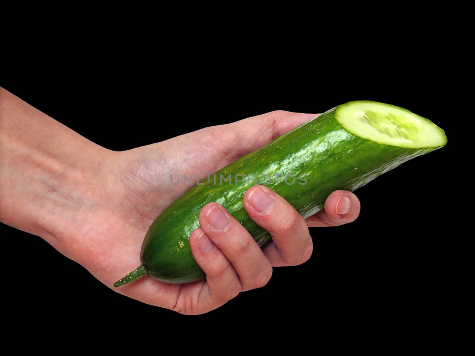 Hand holding a cucumber on black background