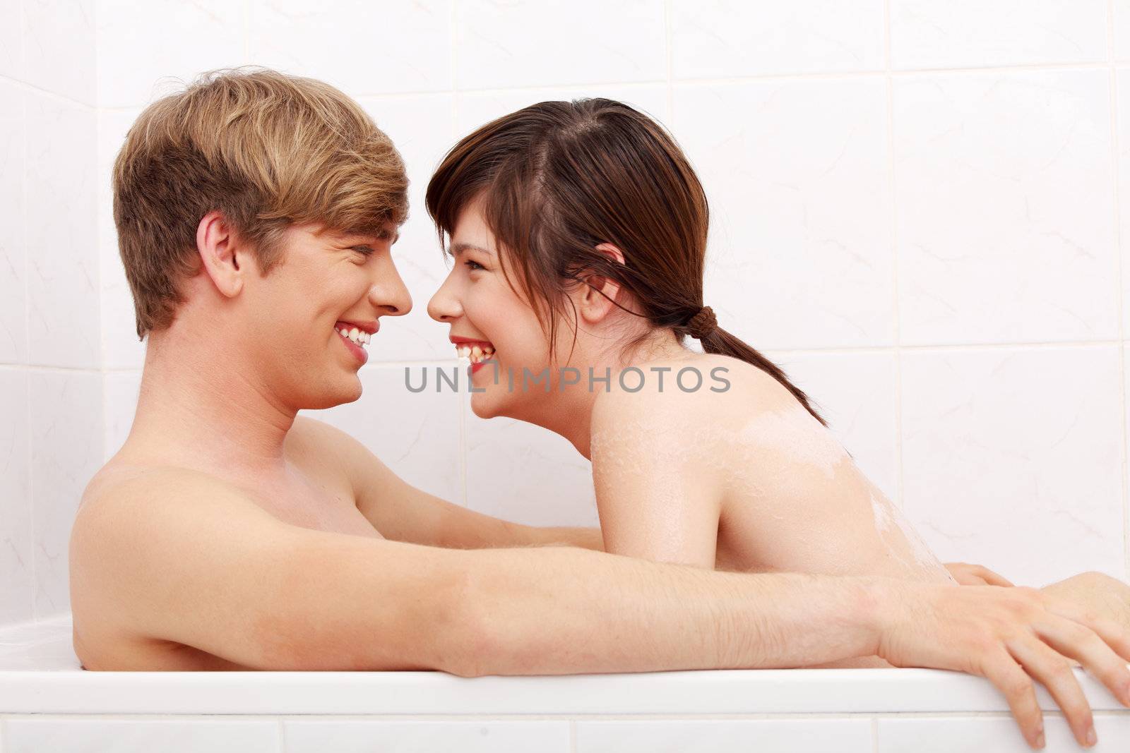 Young happy couple taking a bath.
