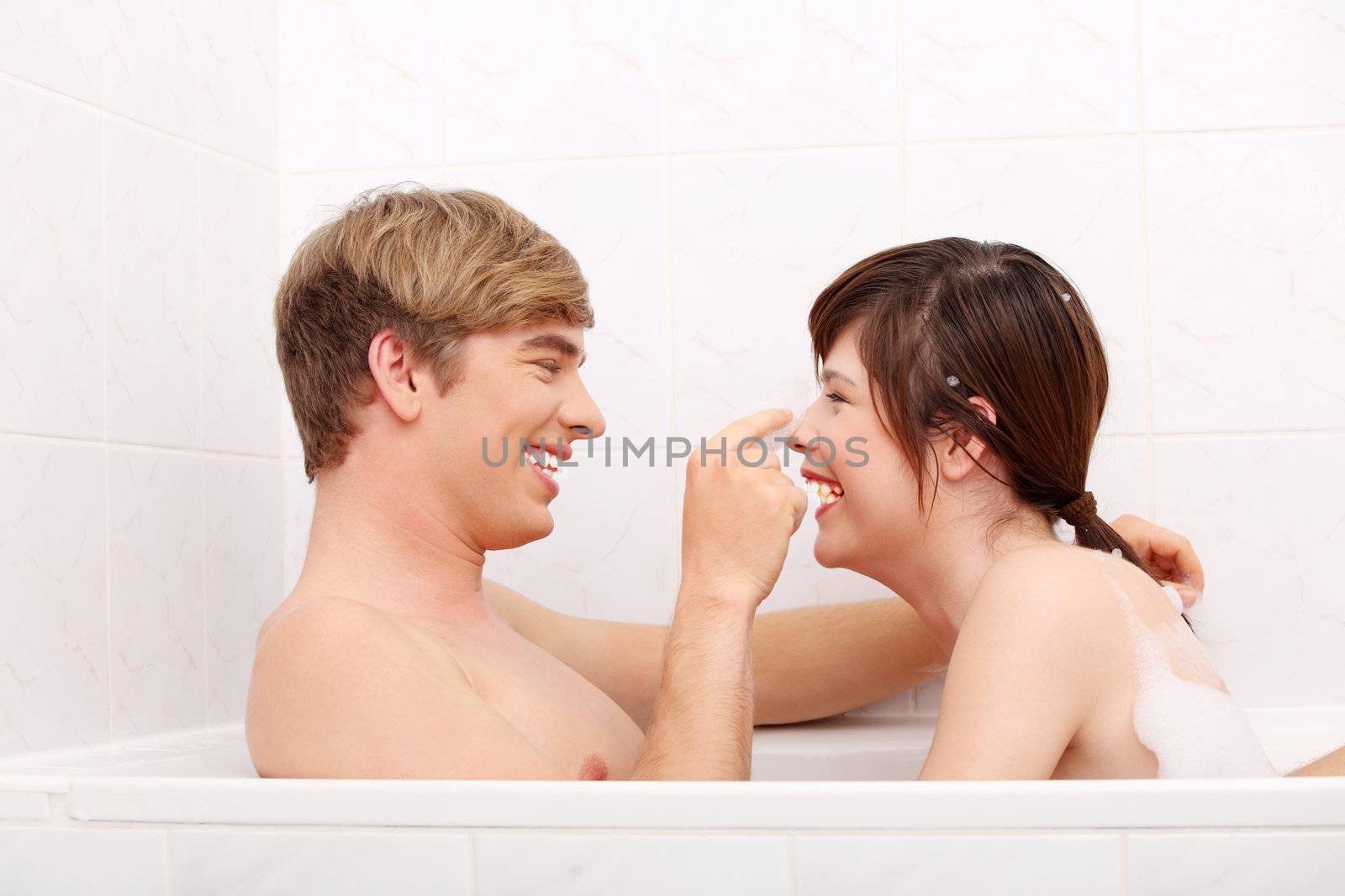 Young happy couple taking bath together.