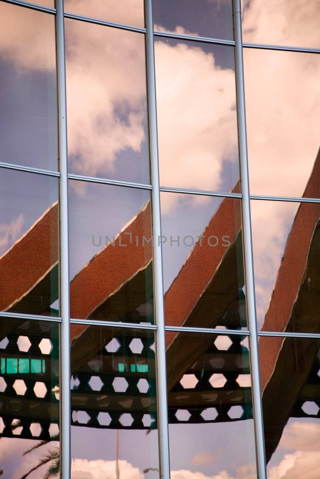 Modern office building with sky and clouds reflections 