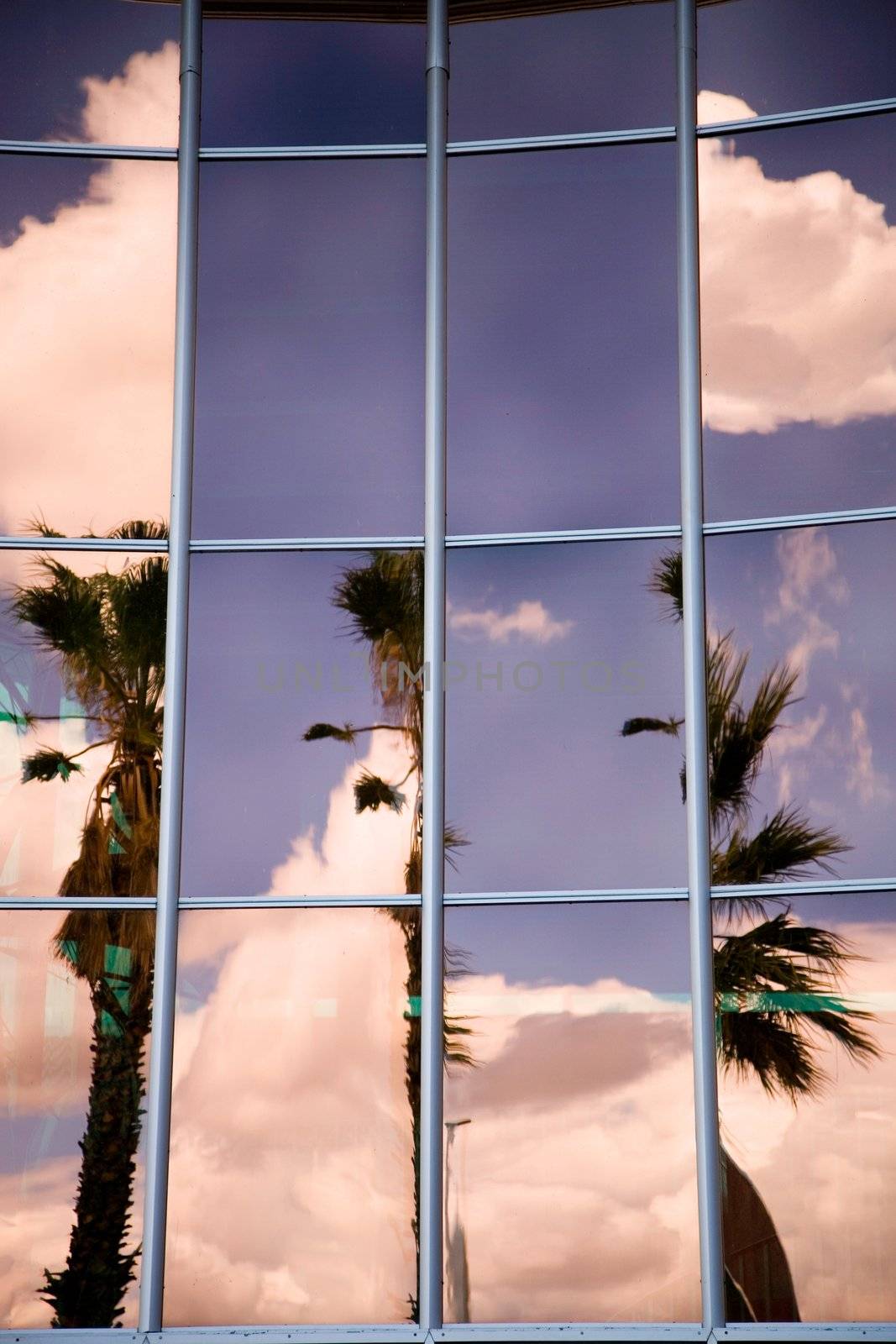 Modern office building with sky and clouds reflections 
