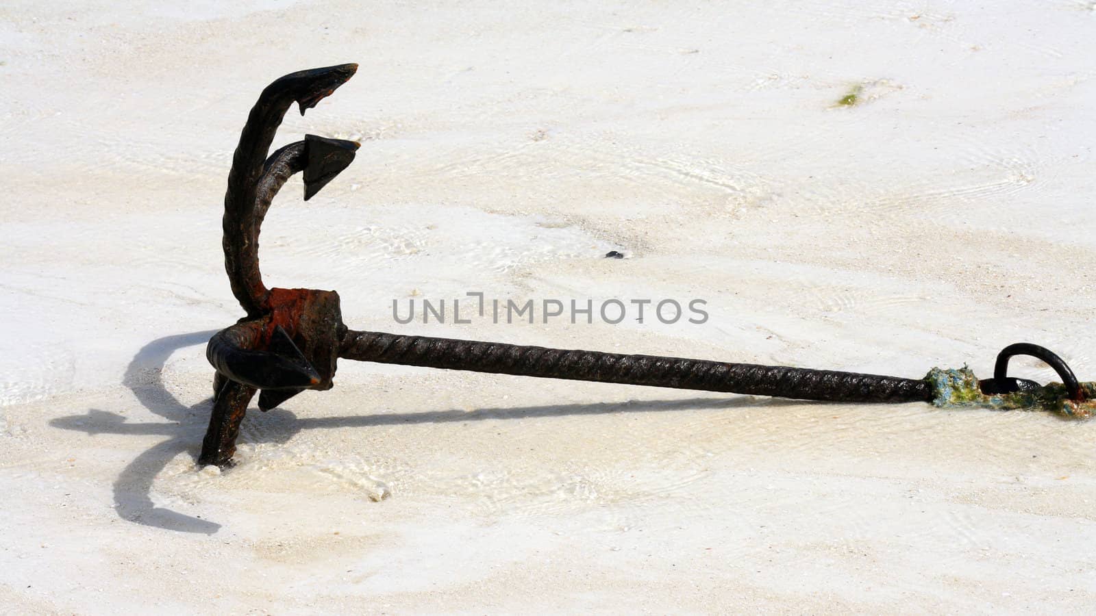 An old anchor on a white sand beach in Zanzibar