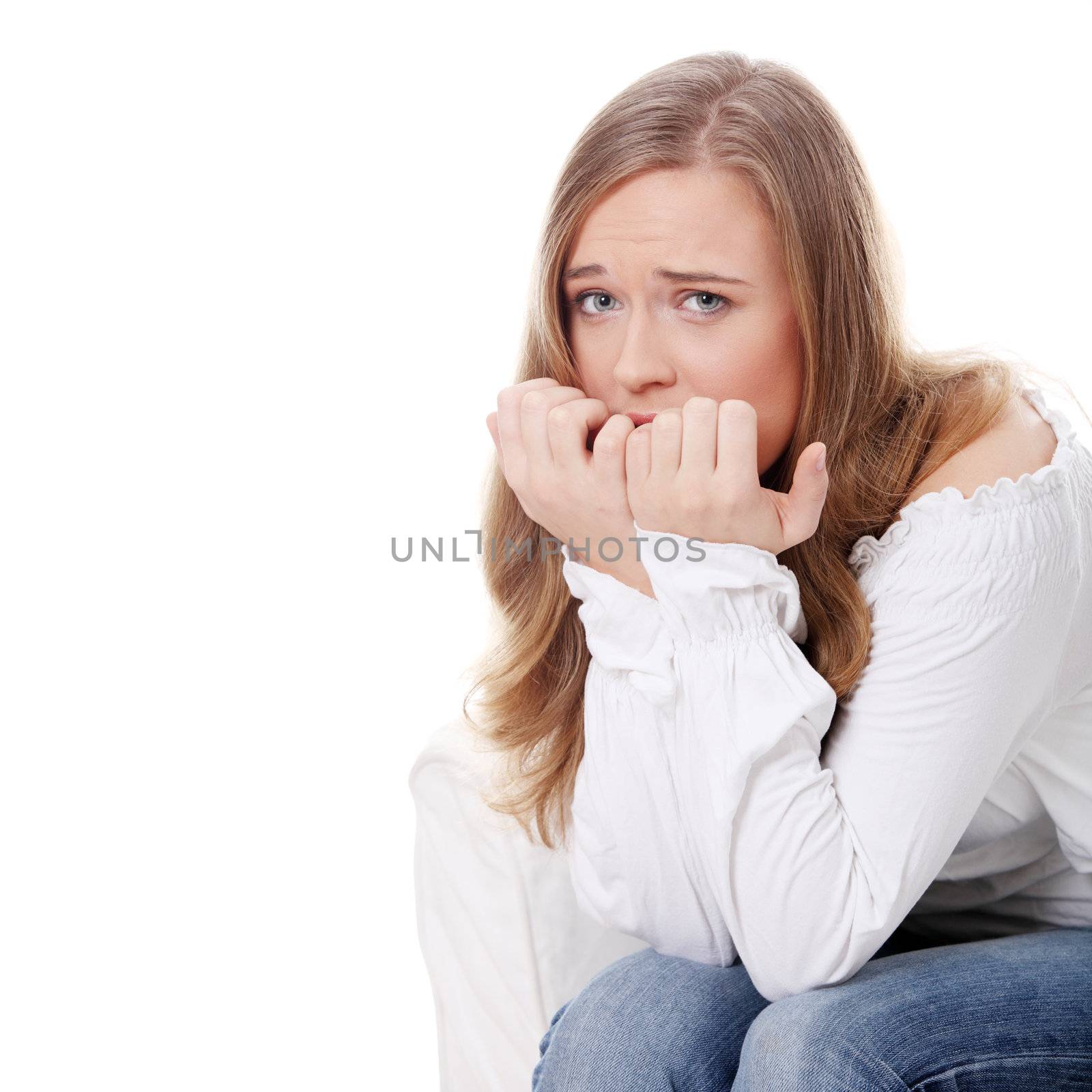 Stressed young woman eating her nails , isolated on white