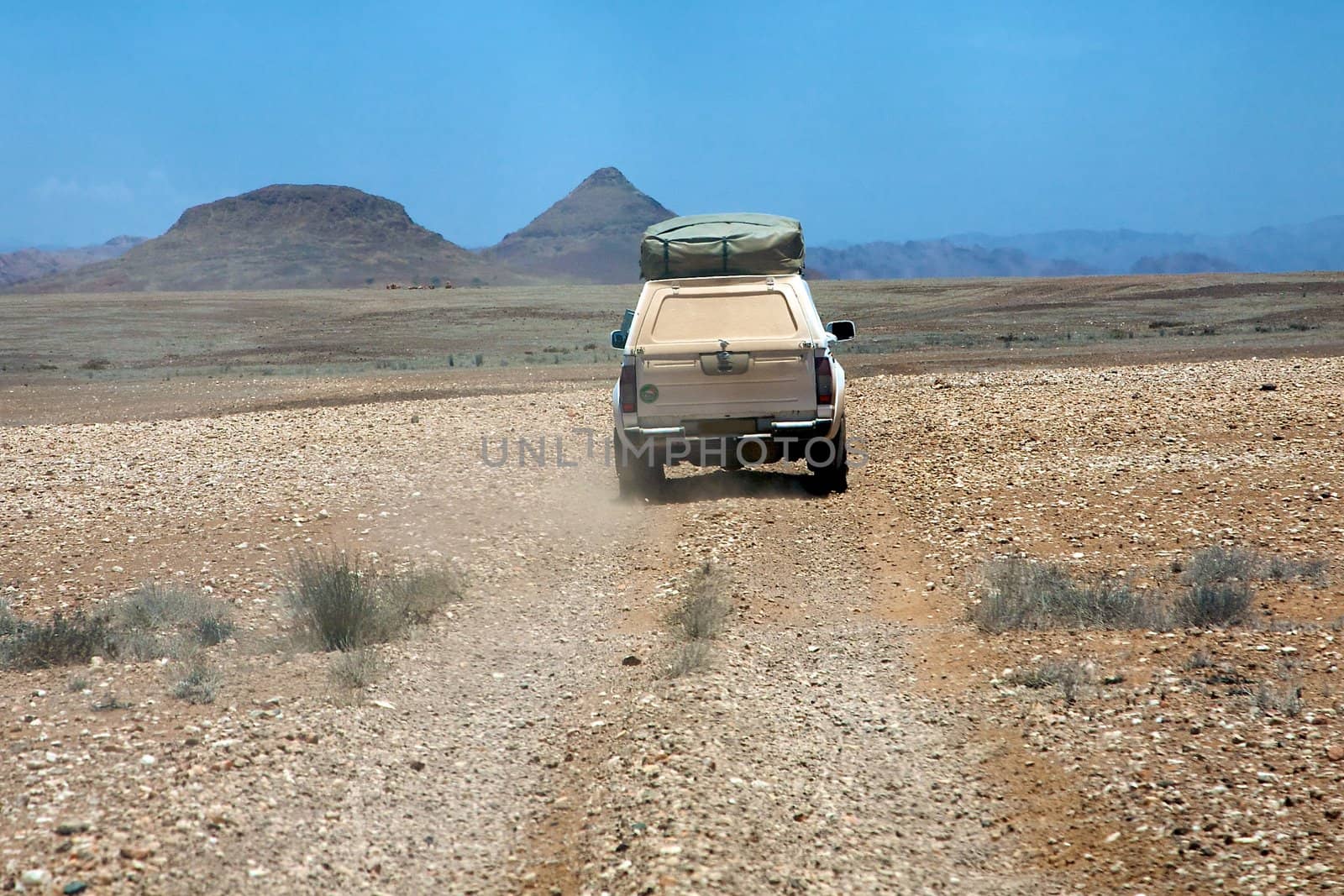 Car driving on a windy gravel road towards Puros