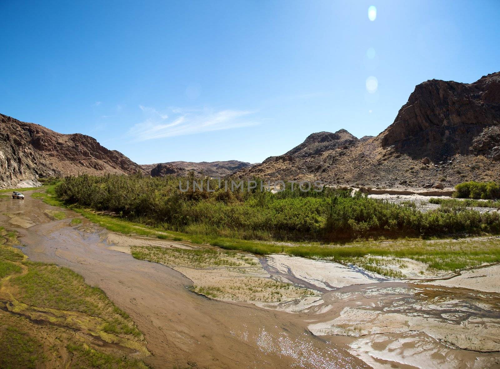 Kaokoland game reserve in Namibia, sand track going toward the Skeleton Coast Desert with a blue sky