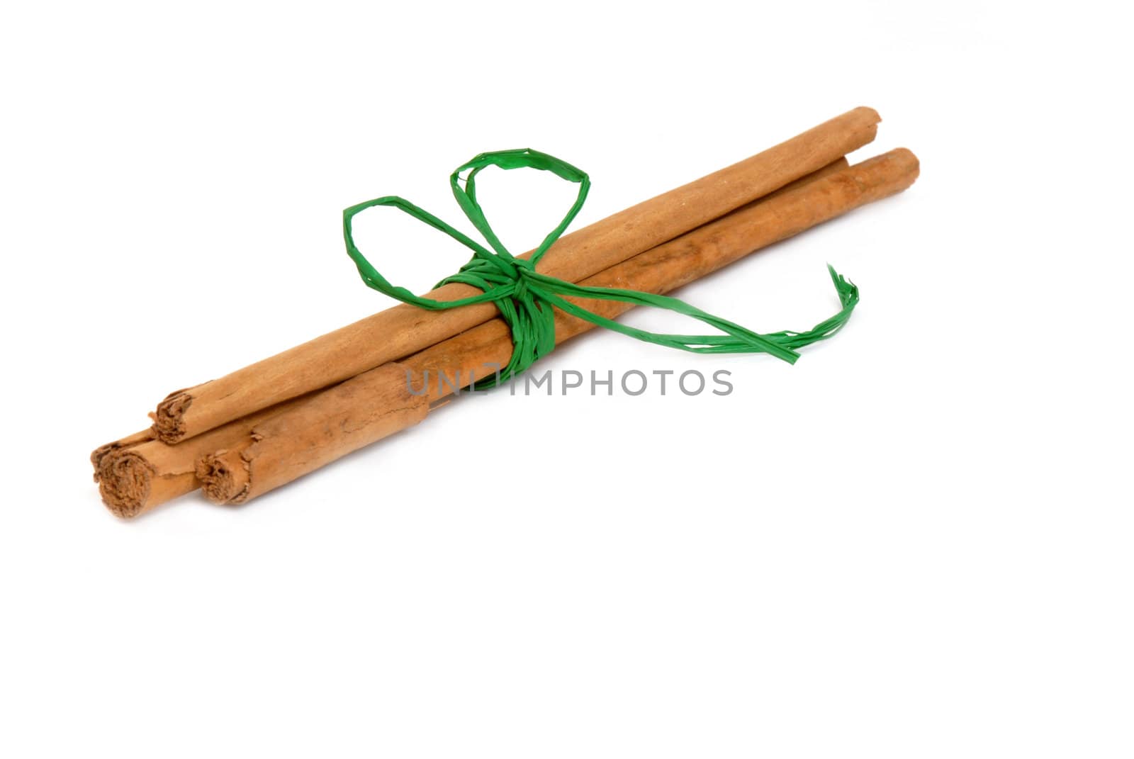 cinnamon sticks tied with a green ribbon isolated on white background 