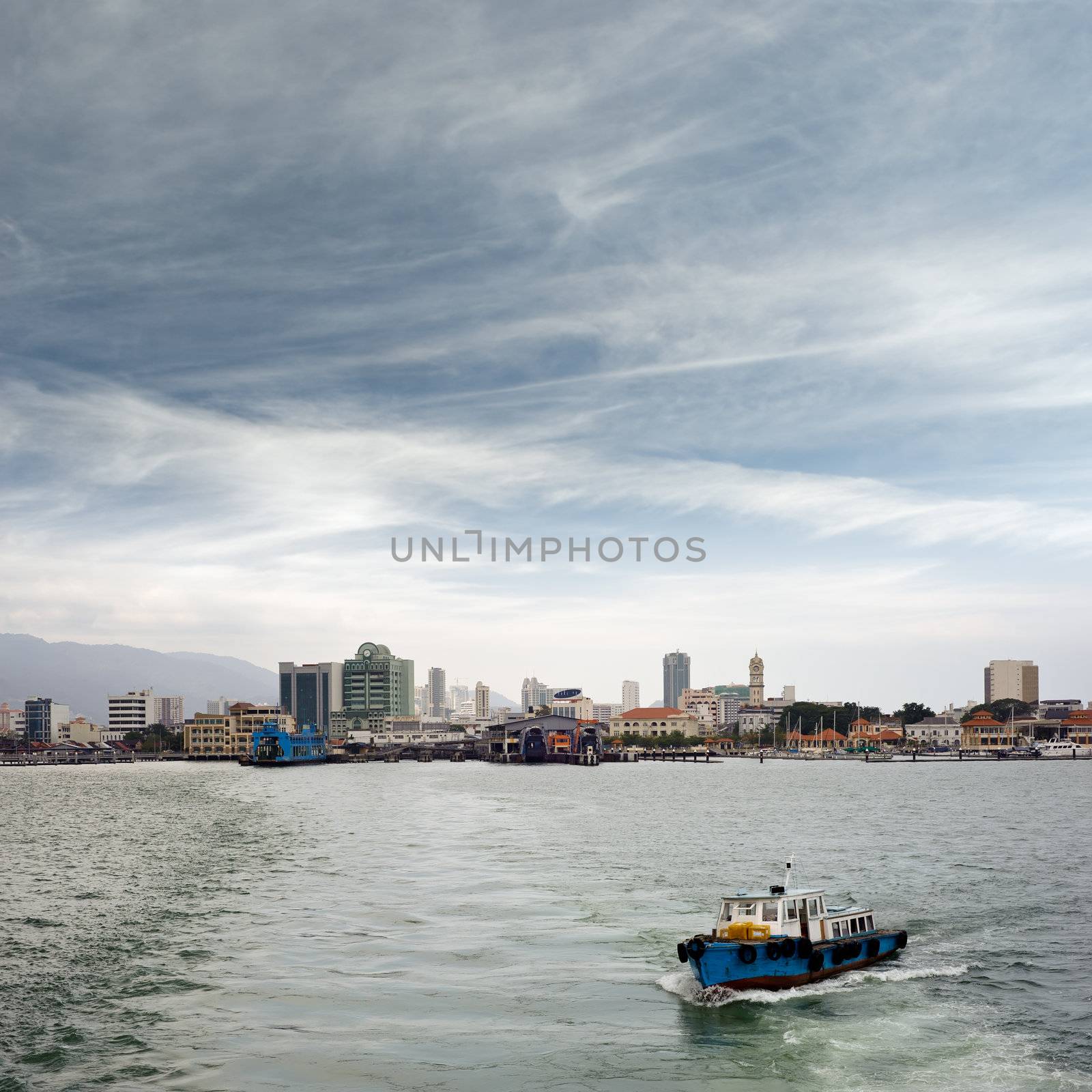 Penang cityscape with boats on ocean and skyscraper in Malaysia, Asia.
