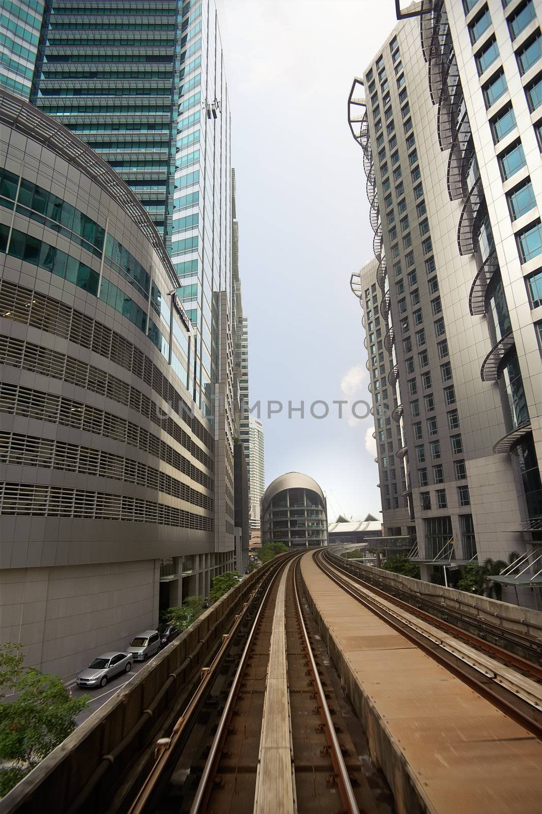 City scenery with railroad over business skyscraper.