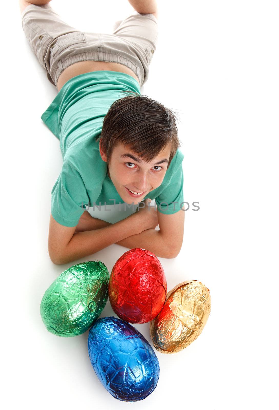 A child with four large easter eggs in front of him.  