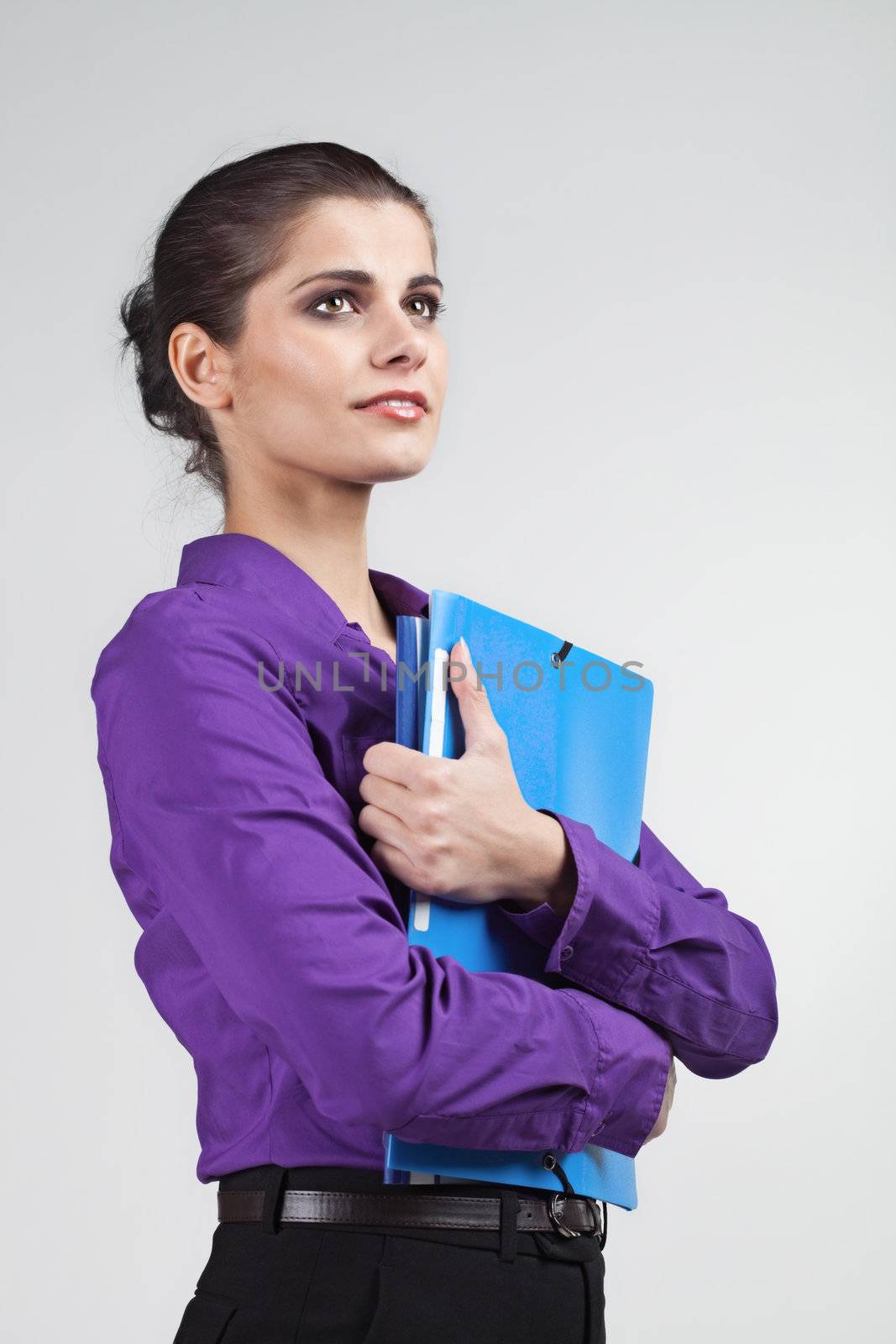 Pretty young brunette woman holding colorful plastic folders