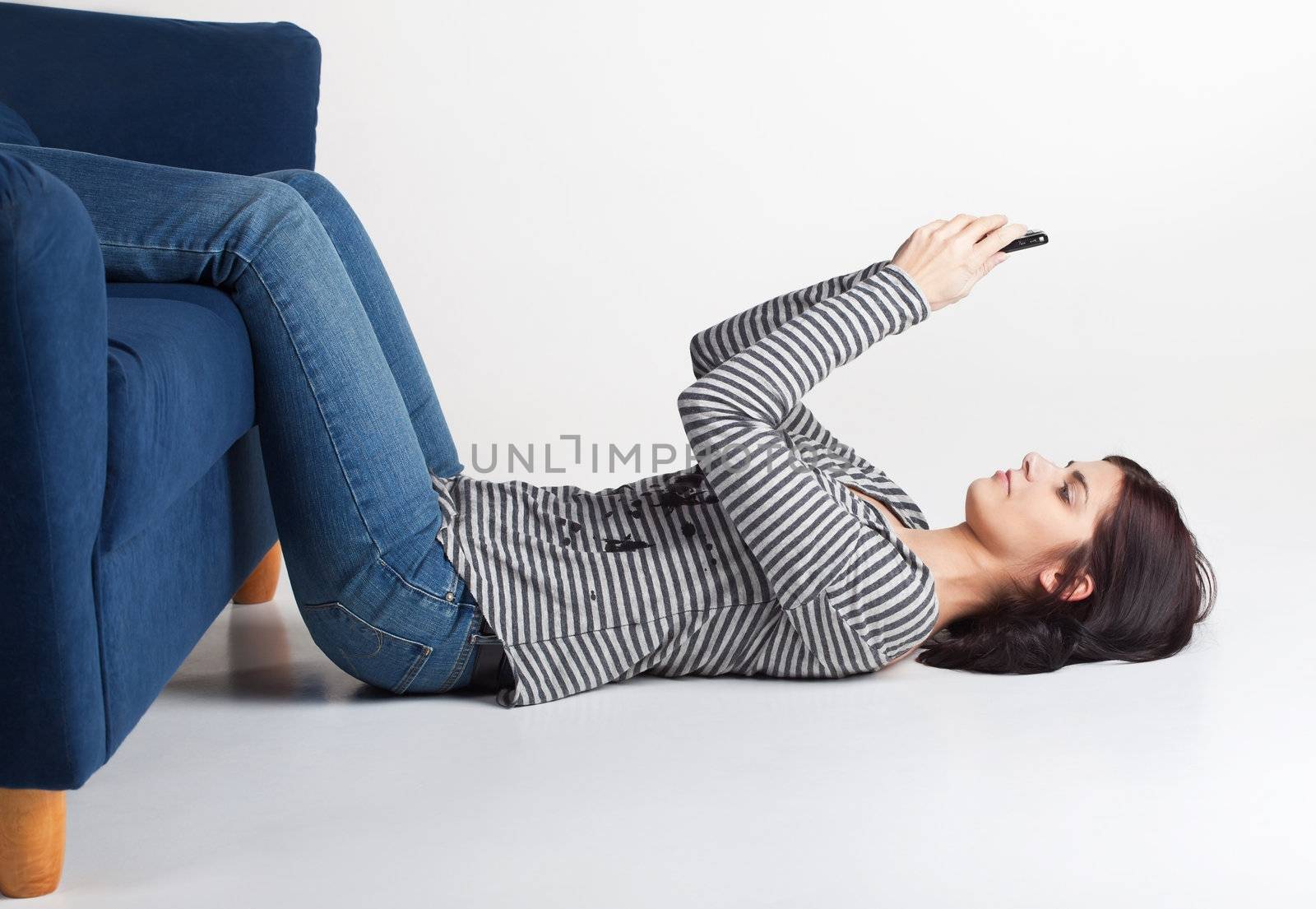 Pretty young brunette woman sending SMS from her cellphone