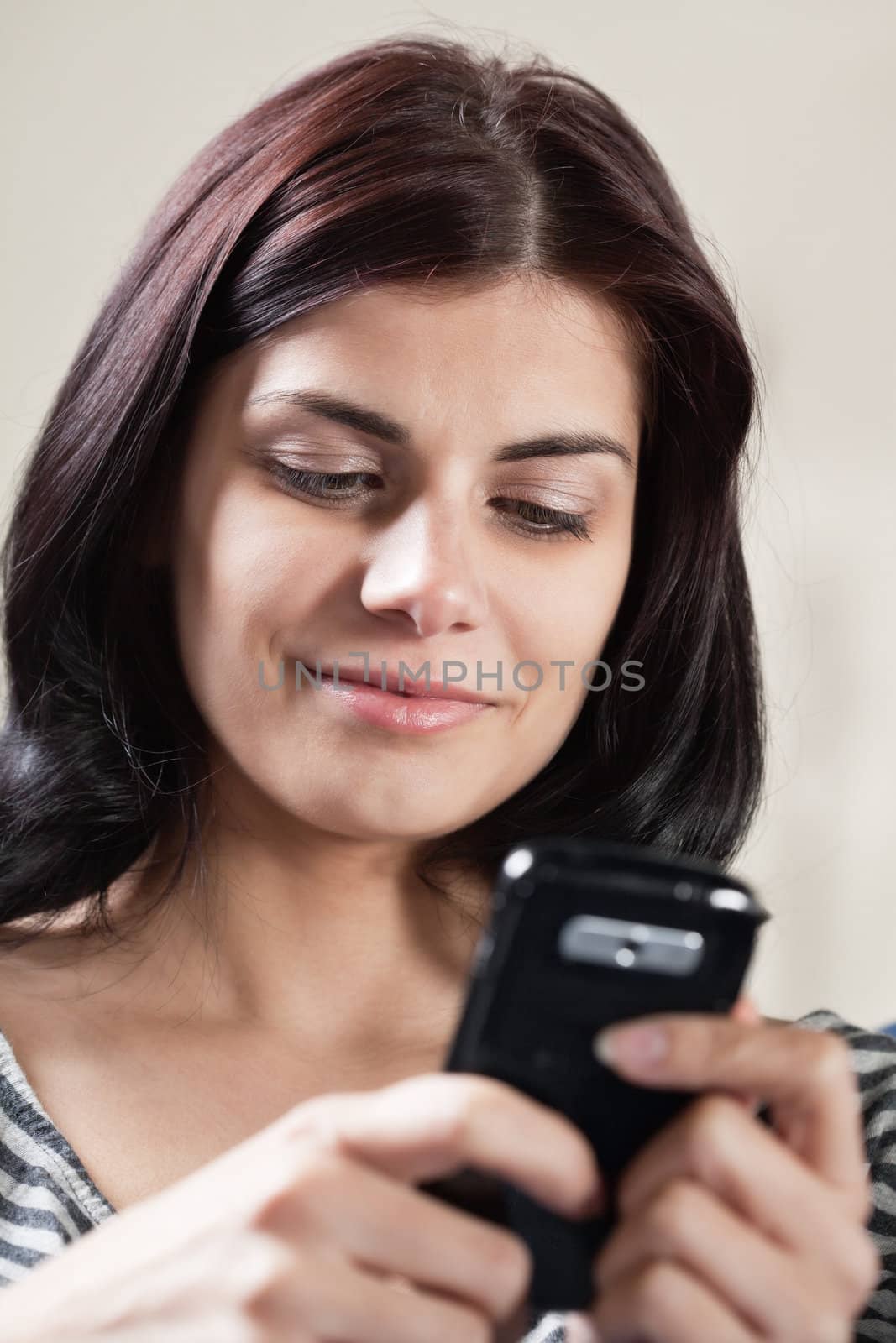 Pretty smiling brunette woman texting with her cellphone
