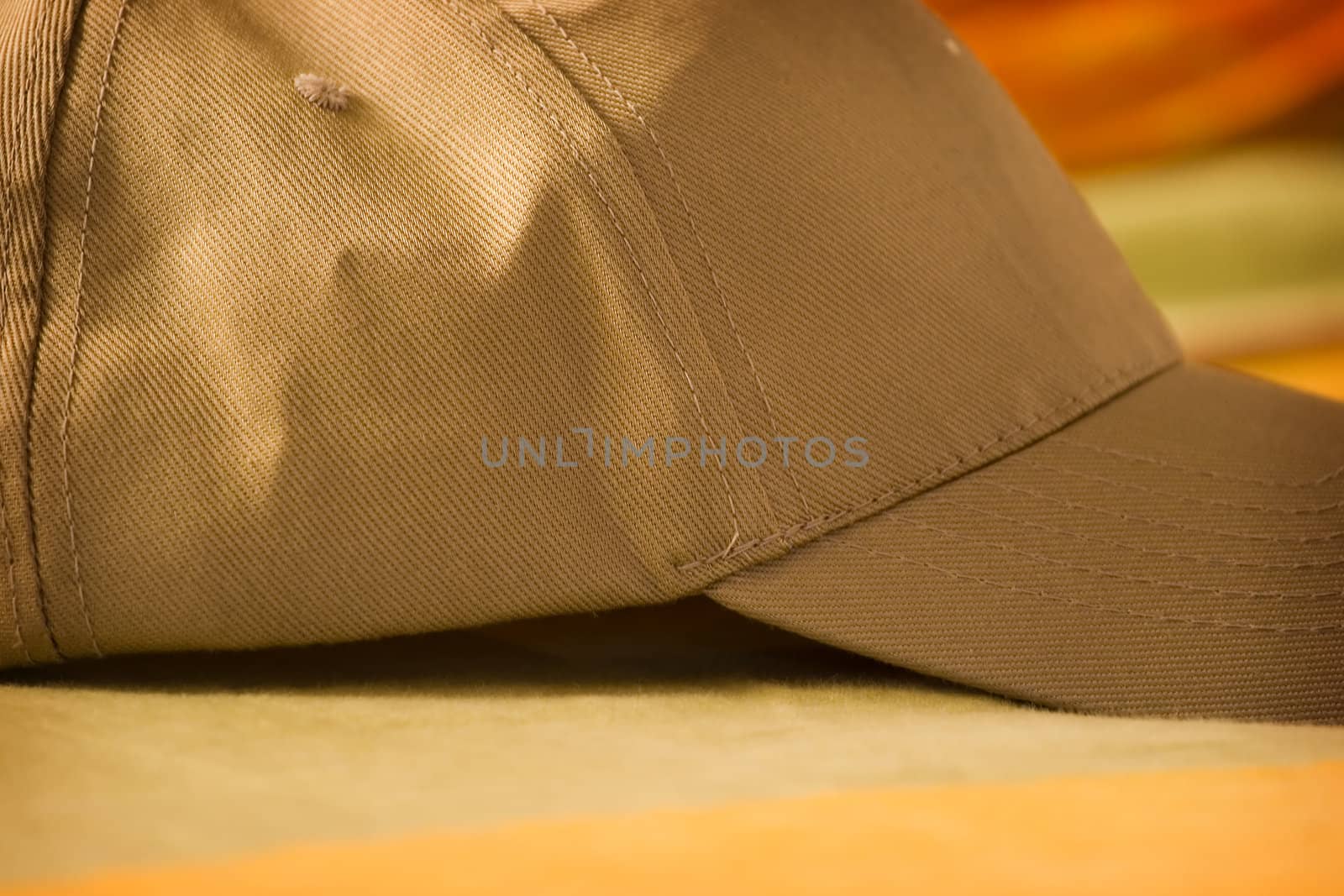 Close up of a brown baseball  hat on colorful surface