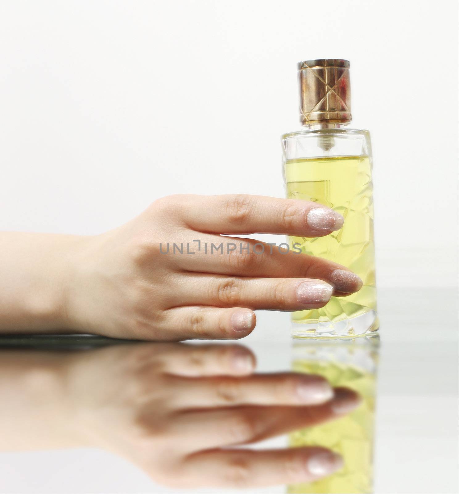 A hand holding a bottle of perfume, feeling elegant, luxury