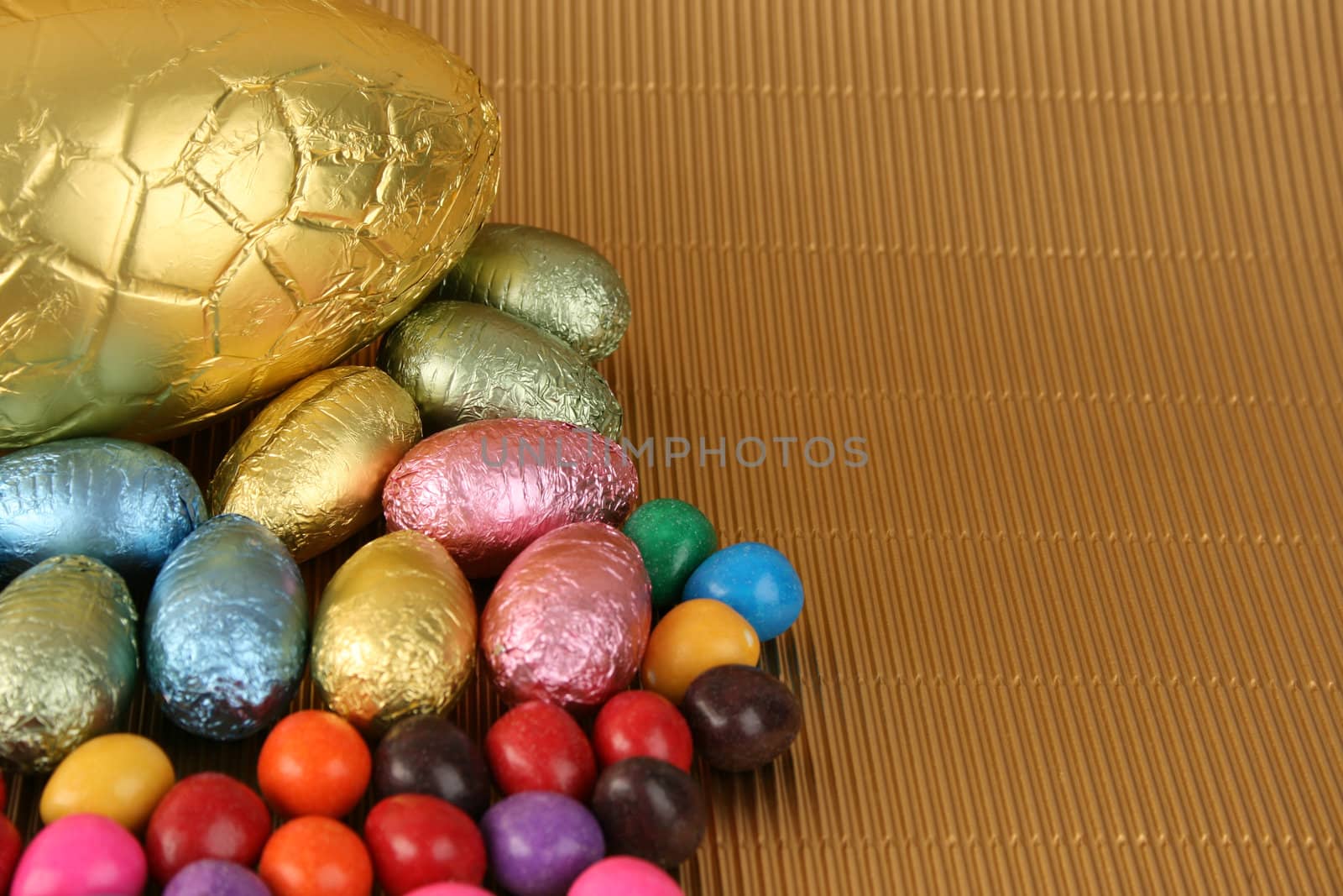 Various colors and shaped easter eggs on a gold background