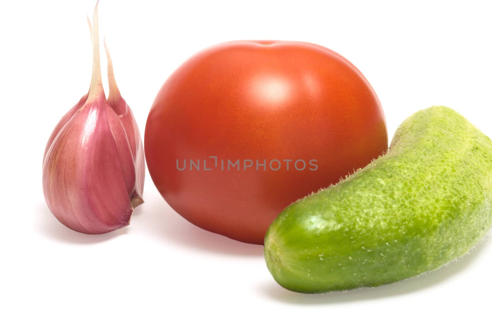 Garlic, tomato and cucumber closeup on a white background.