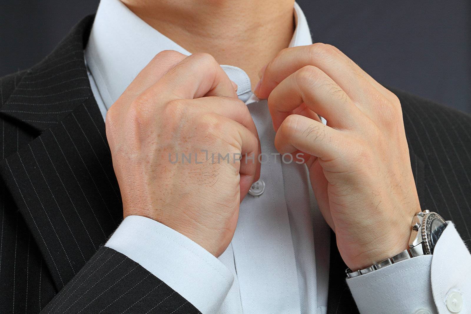 young man adjusting his suit on a black background  by cozyta
