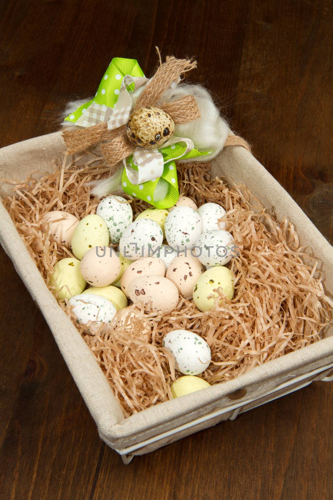 Colorful chocolate easter eggs in brown basket 