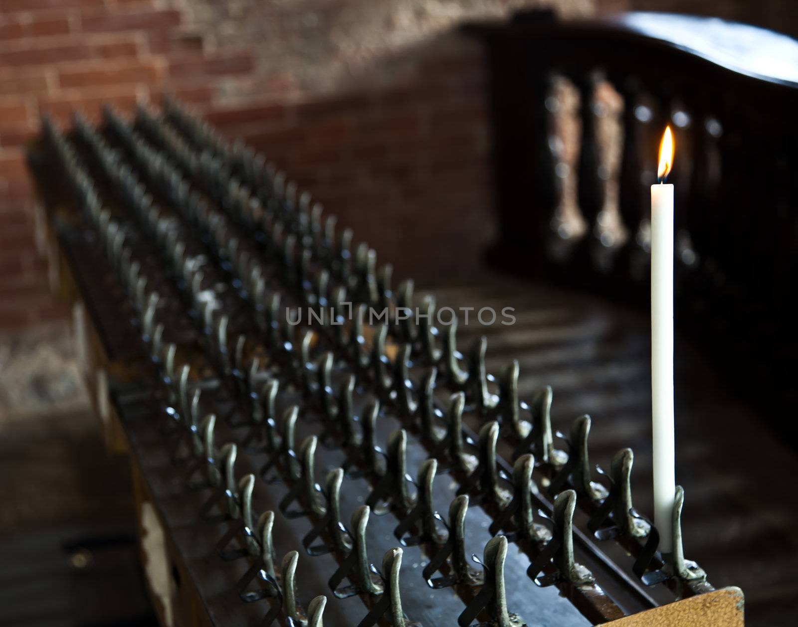 Lonely candle in a Italian Abbey. Concept of hope, faith, loneliness