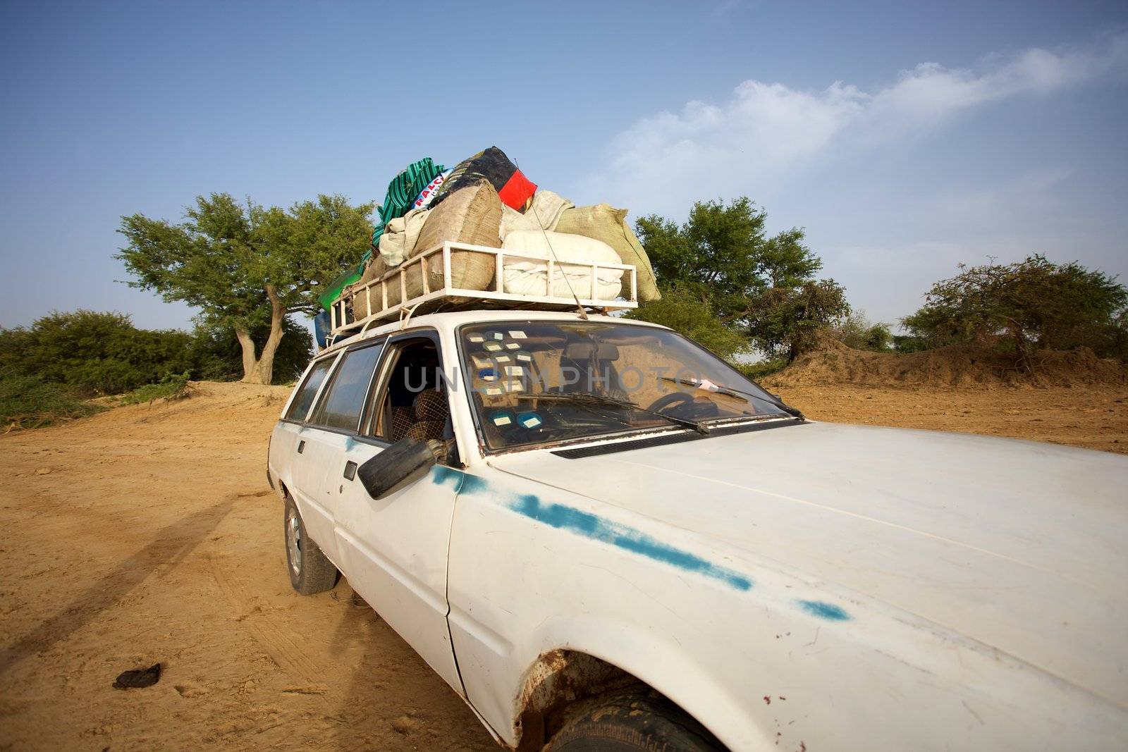 Over loaded taxi on a road of Mali