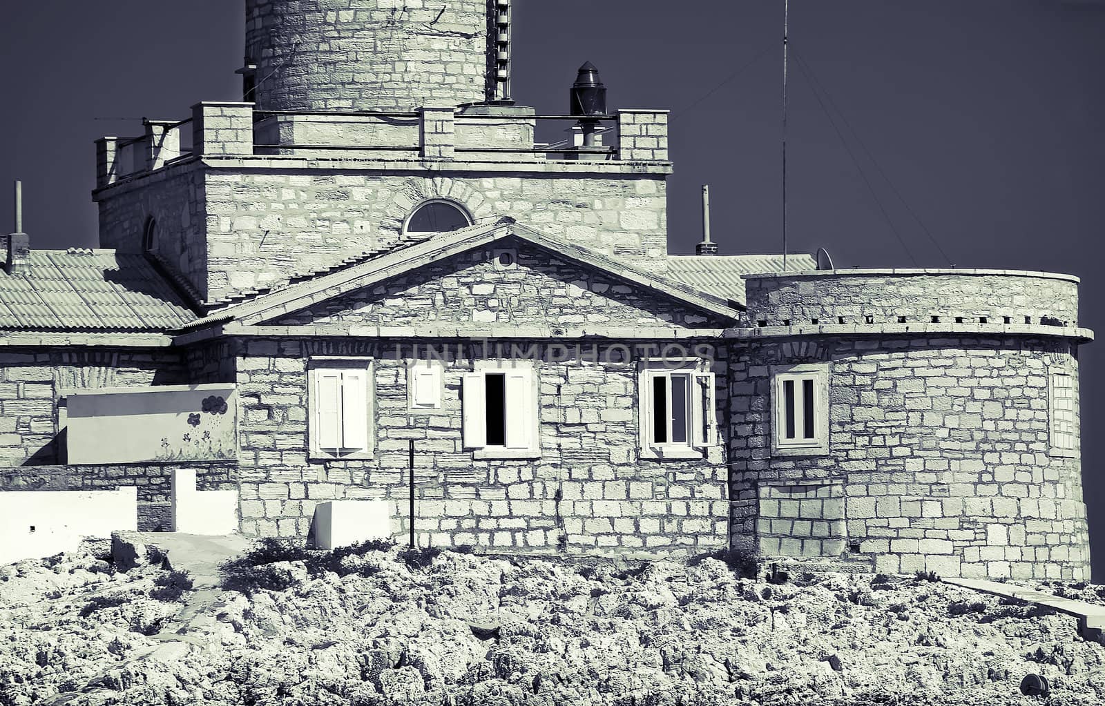 Old stone lighthouse , black and white toned photo