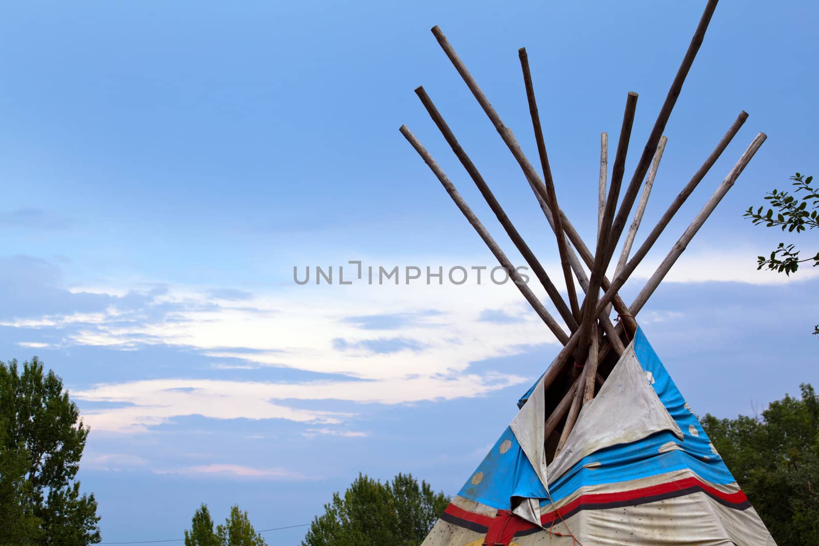 Wooden wigwam against the blue sky
