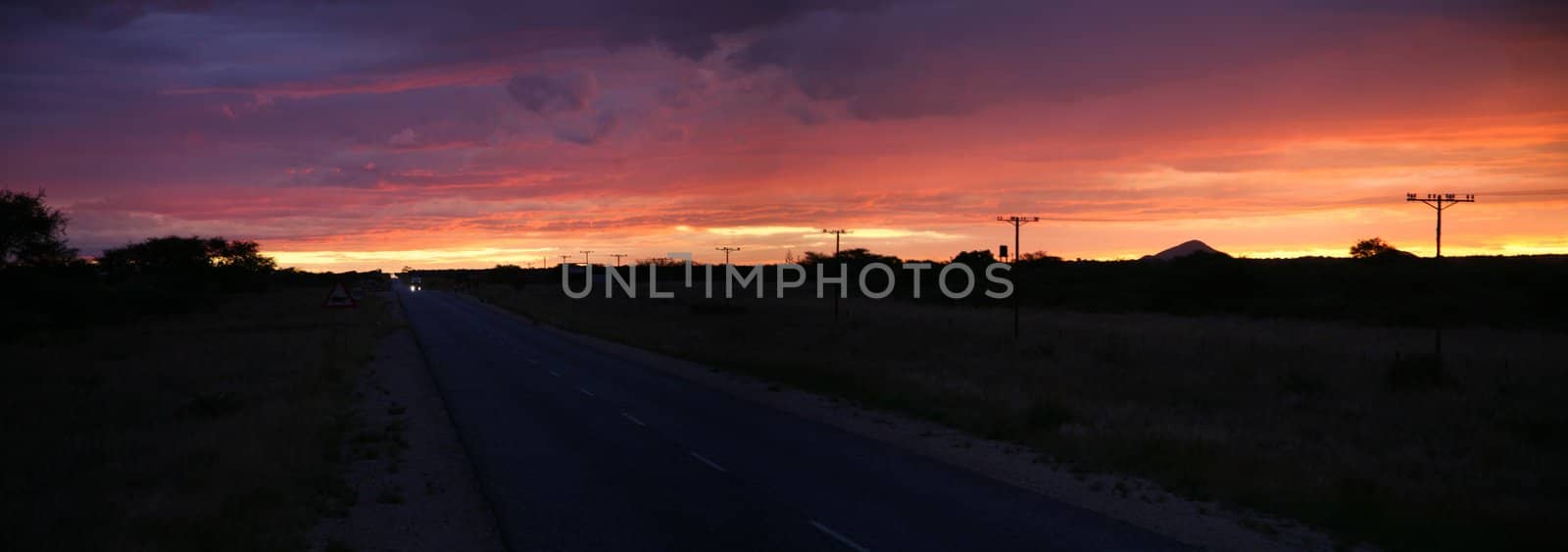 Road and sunset over the wide rural african landscape in Namibia, South West Africa.