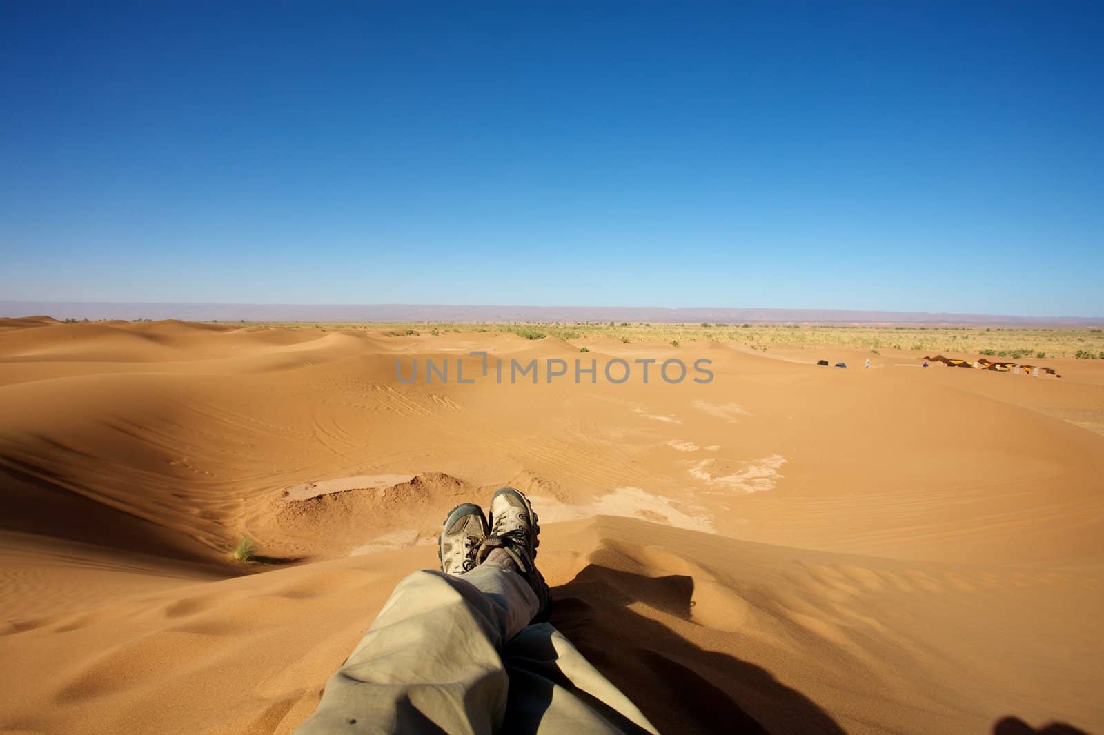 Man sitting in the dunes of Merzouga in Morocco